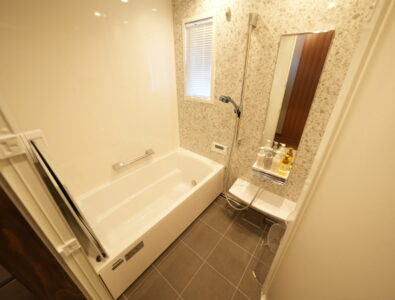 Modern bathroom with bathtub, rainfall shower, and luxury toiletries at Enishiya Izumo Villa, offering a relaxing bathing experience.