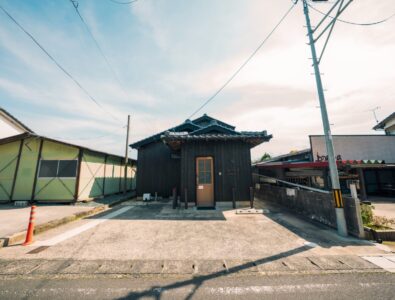 Traditional wooden exterior of Enishiya Izumo Villa, showcasing the rustic charm and spacious parking area.
