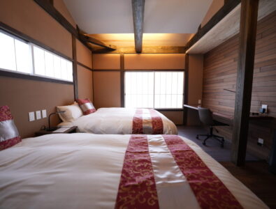 Twin bedroom with traditional wooden beams and modern comfort at Enishiya Izumo Villa.