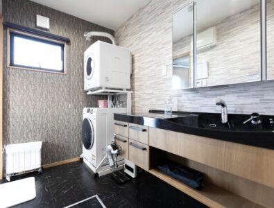 Laundry room with stacked washer and dryer, featuring modern utilities at Ocean Villa Naruto.