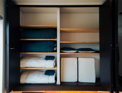 Spacious closet with neatly stacked futons, pillows, and bedding at Ocean Villa Tokunoshima.